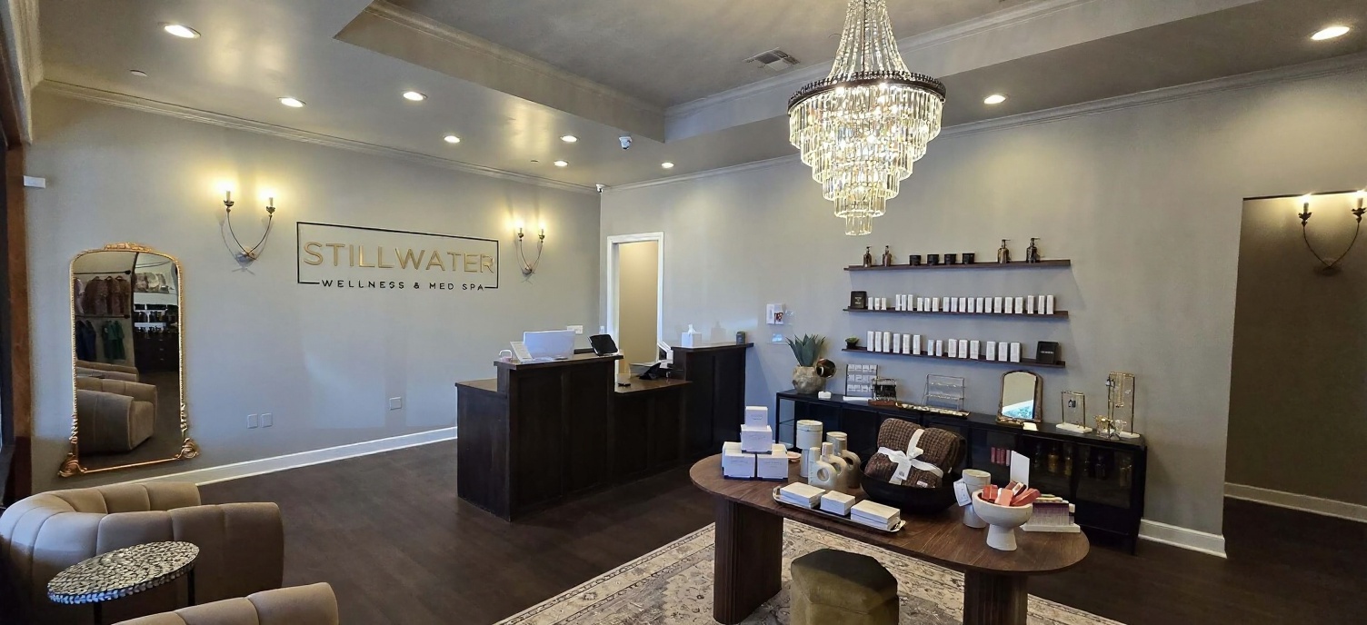 The Stillwater reception — STILL WATER signage above the walnut desk